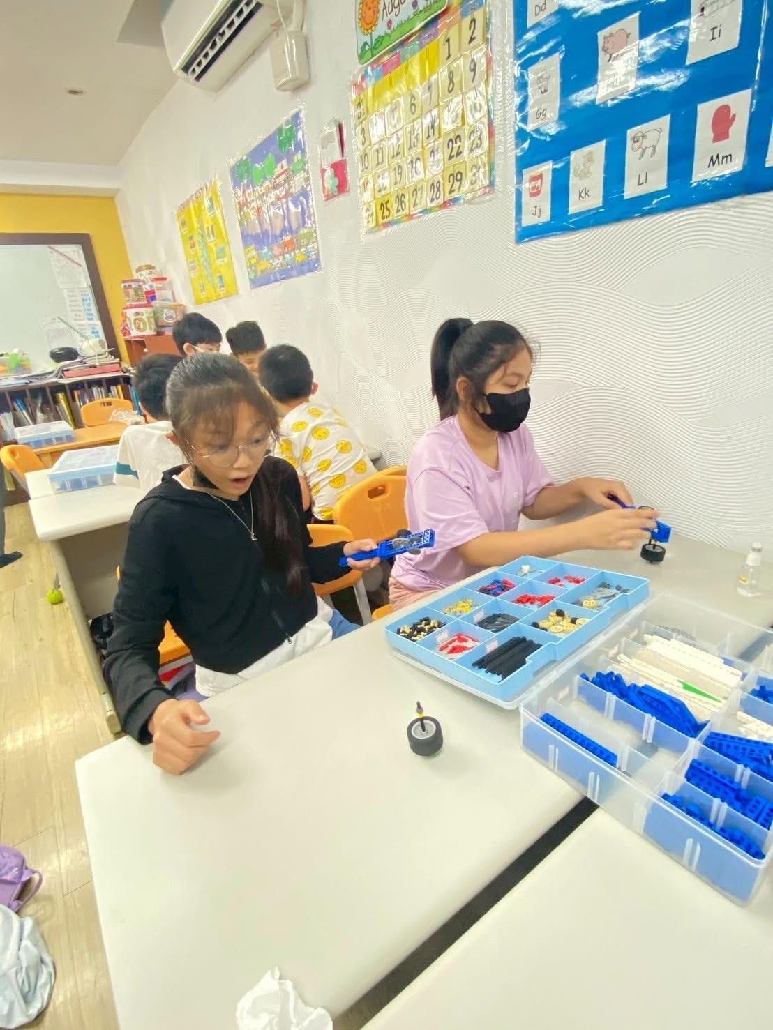 Students building with construction bricks during class